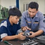 Guru memberikan umpan balik kepada siswa SMK saat mengerjakan proyek praktik di bengkel sekolah